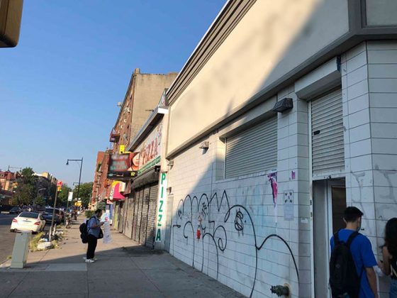 A sidewalk view of five blighted retail stores before construction.