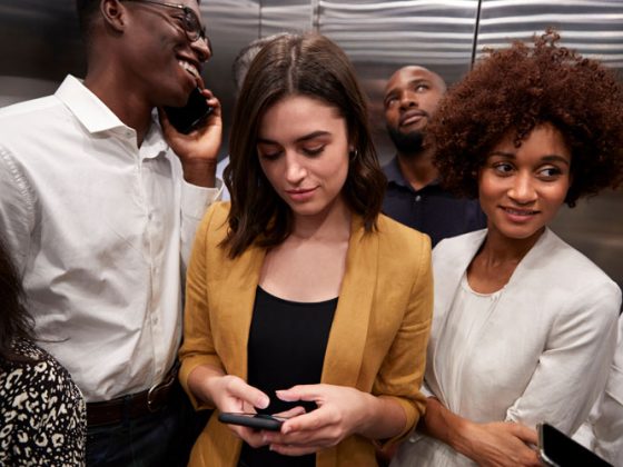 A diverse group of business people inside an elevator.