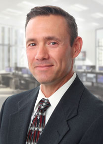 Male dressed in a suitcoat and tie smiling.