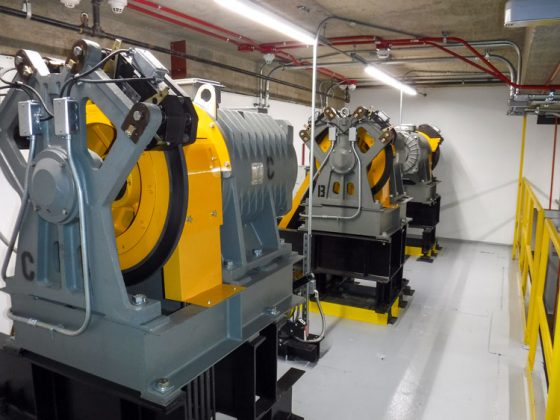 An elevator machine room with gray and yellow machinery.