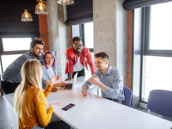 A diverse team of architecture and engineering interns meet in a modern office.