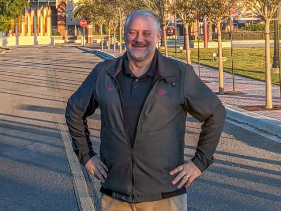 Eric Abrams, senior project manager, stands in front of the Florida State University Doak Campbell Stadium on a fall day.