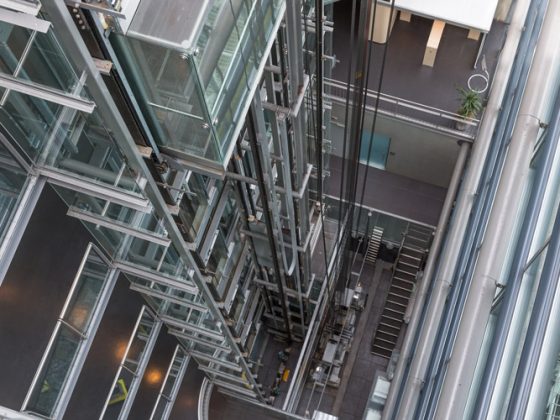 Looking downward in a modern open elevator shaft.