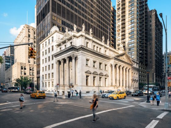 Exterior view of the distinctive white marble-clad courthouse on a busy stretch of Madison Avenue.