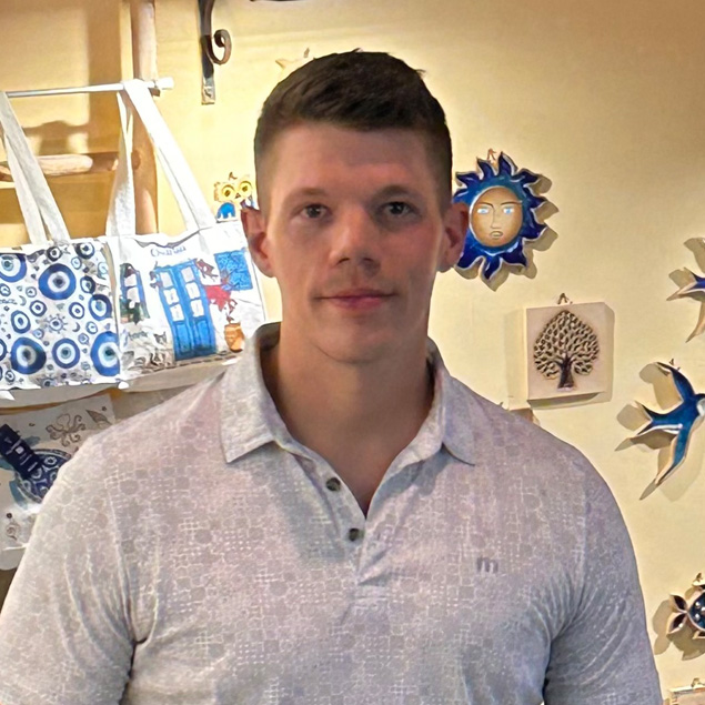 A man standing in front of a store wall.