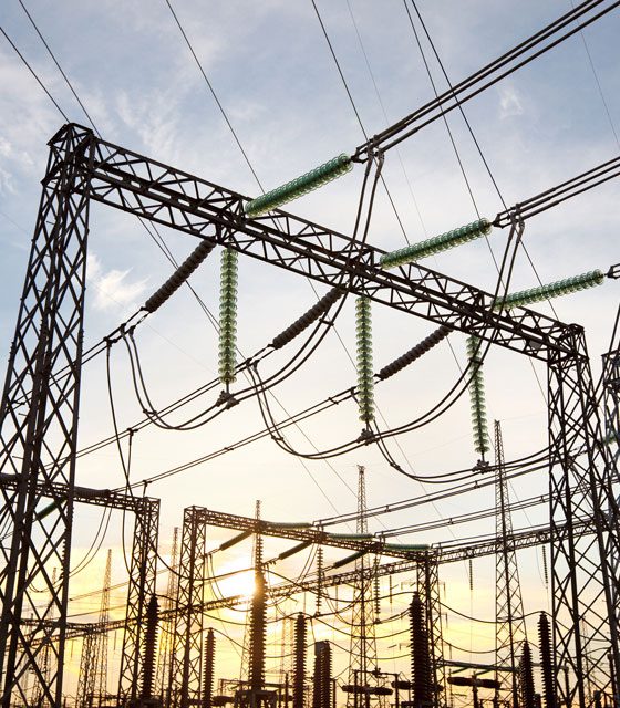 An electric power substation with wires hanging in the sky on a sunny sky.