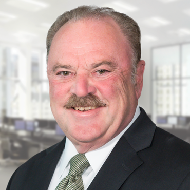 A portrait of Anthony Ferruccio smiling. He is wearing a white button up shirt, sage green tie, and a black suit jacket.