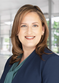 A woman with a navy-blue suit jacket and green blouse.